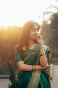 A serene portrait of a young woman in a green saree, captured beautifully at sunset, exuding elegance and cultural grace.